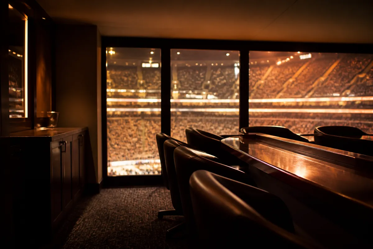 An empty private suite overlooking a lit arena bowl